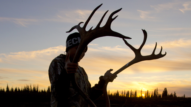 Caleb Stalker, 15 years old, holds the antlers of a caribou he helped harvest on his first caribou hunt. Providing for the community, sharing, and learning are Iñupiaq values that are taught with great care.